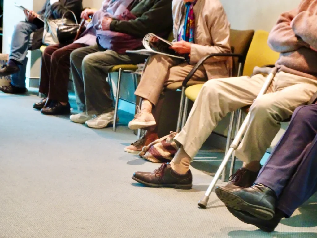 a-row-of-people-sitting-in-a-waiting-room-symbolbild