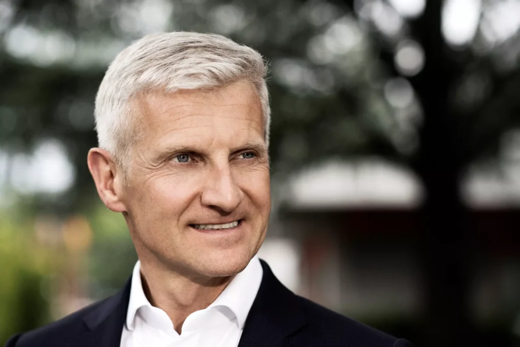 Wir sehen den Kaffeeunternehmer Andrea Illy, er ist ca 50, hat graue Haare, sportlich mit schwarzem Anzug und weißem Hemd