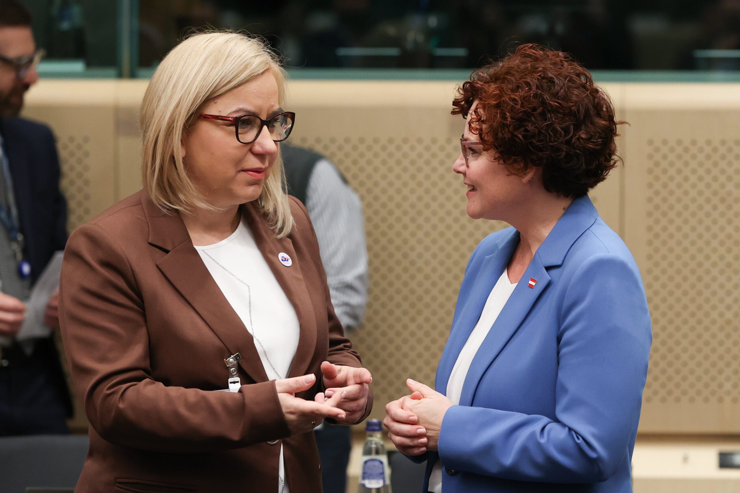 Zwei Frauen in Business-Anzügen im Gespräch.