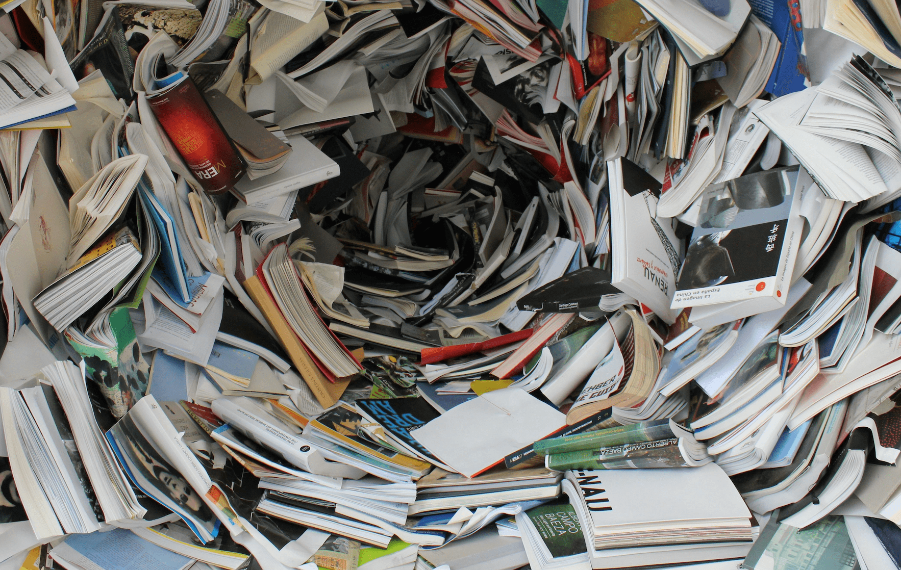 Viele offen gestapelte Bücher in Spiralform.