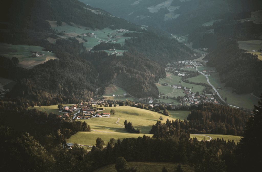 Malerische Alpenlandschaft mit Dorf und Wald.