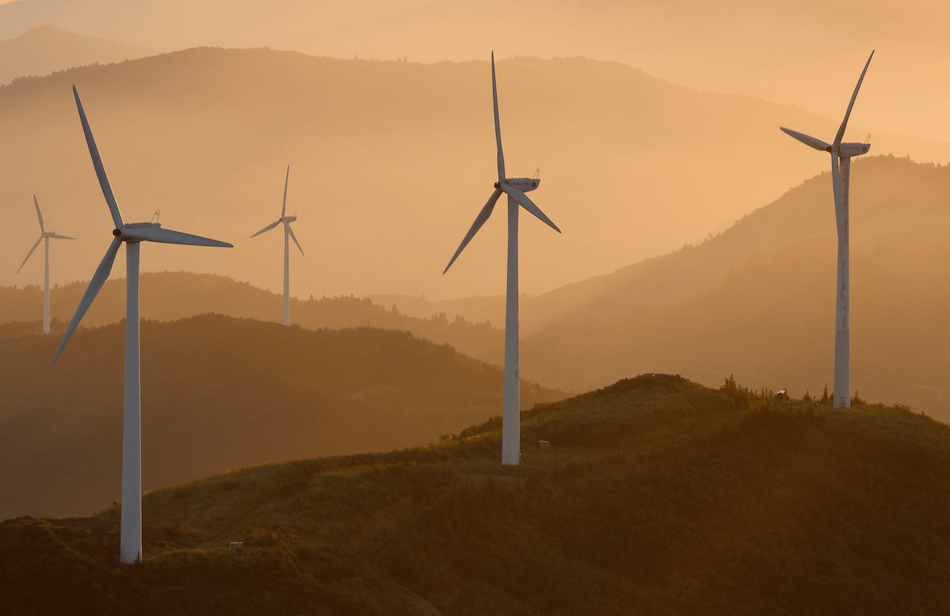 Windkraftanlagen im Sonnenuntergang auf Hügeln