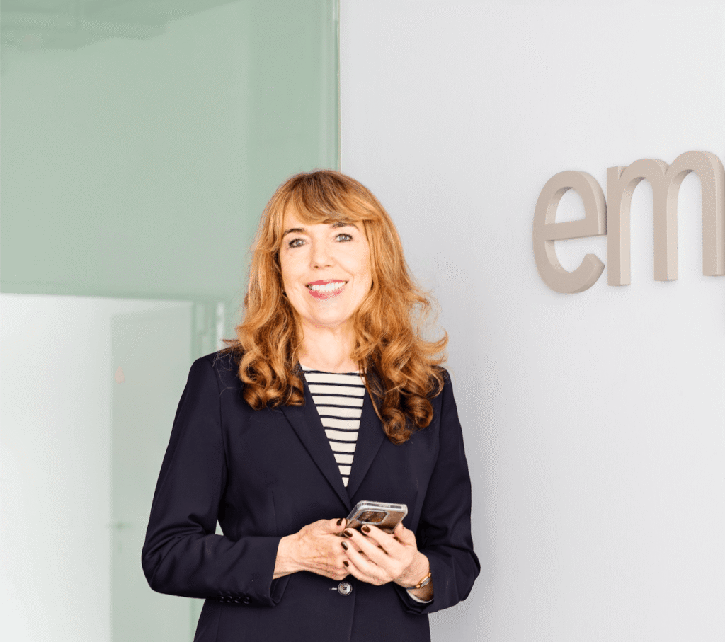 Frau mit Smartphone vor Wandbeschriftung