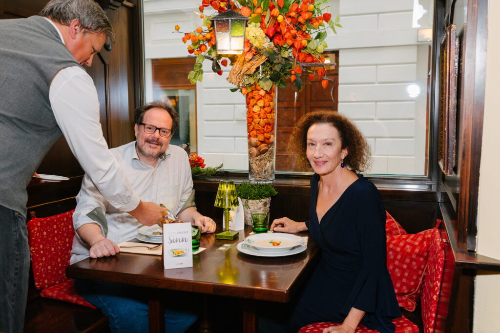 Paar im Restaurant wird vom Kellner bedient