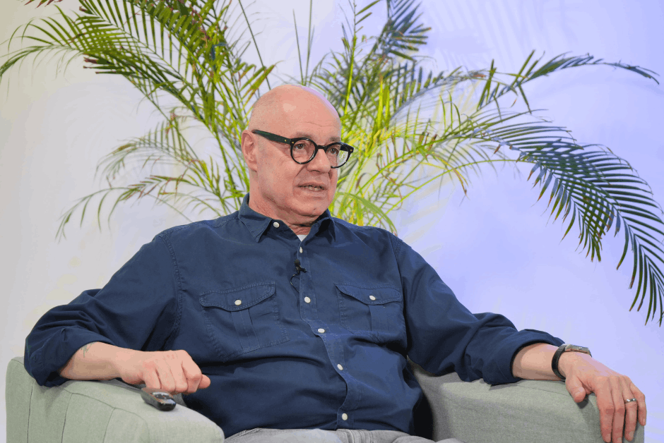 Mann sitzt in grünem Sessel mit Pflanzen