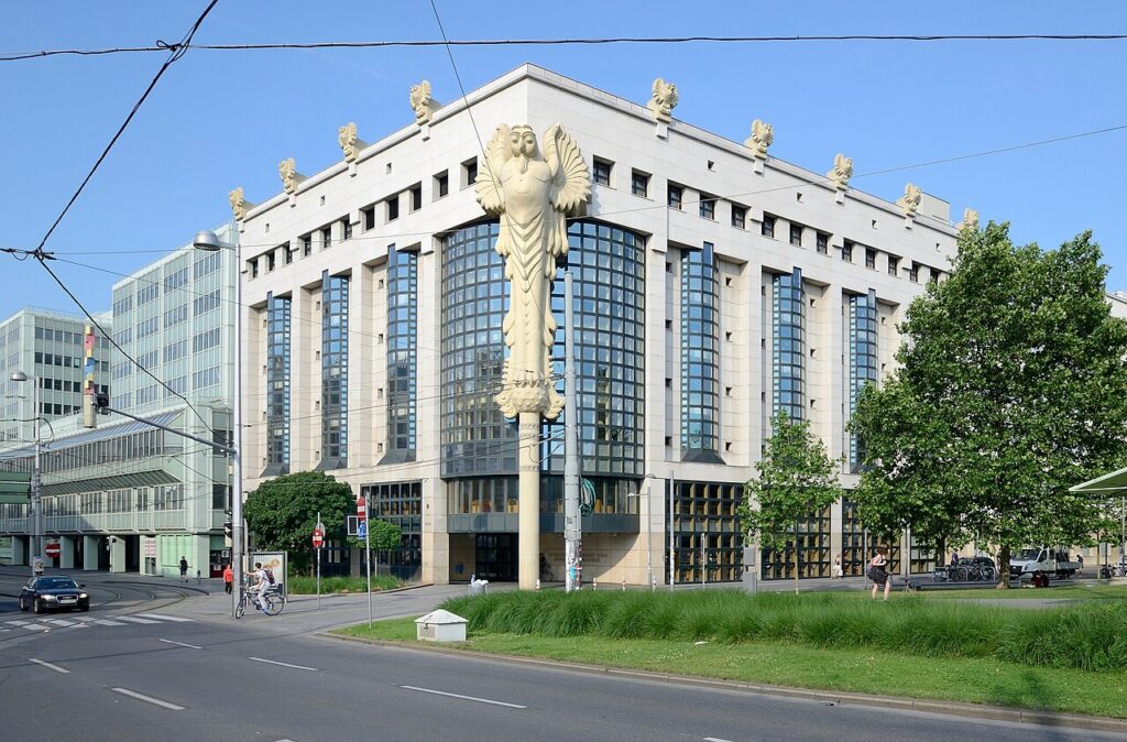 Großes Gebäude mit Eulenskulptur an Straßenkreuzung